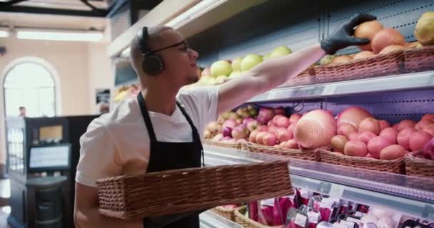 Man Werknemer Opslag Van Vruchten Supermarkt Terwijl Luisteren Naar Muziek — Stockvideo