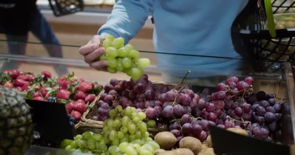男子手在超市里挑选葡萄 放在篮子里 — 图库视频影像
