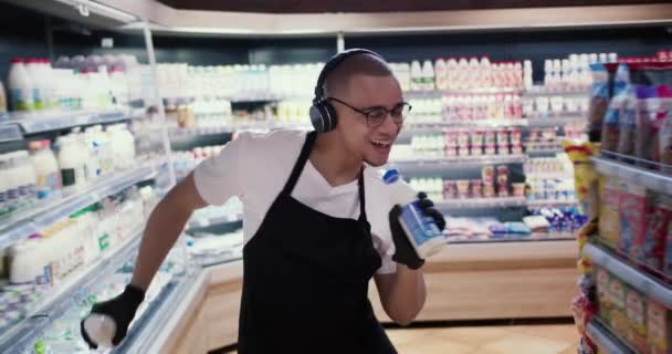 Glücklicher Arbeiter Supermarkt Tanzt Und Singt Den Milchflaschen — Stockvideo