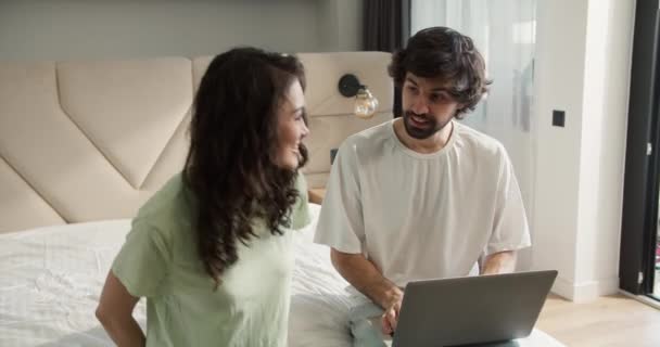 Молодая Женщина Показывает Положительный Тест Беременность Мужу Сидящему Кровати — стоковое видео