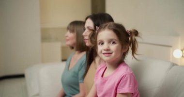 Üç kuşak kadın. Güzel büyükanne, anne ve kızı kameraya bakıyor ve sırayla gülümsüyor..