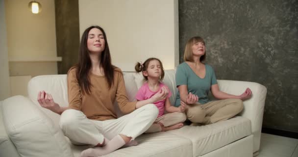 Two Mature Women Little Girl Sitting Sofa Yoga Pose Meditating — Stock Video