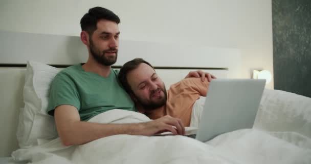 男同性恋夫妇在家里躺在床上 用笔记本电脑看电影 — 图库视频影像