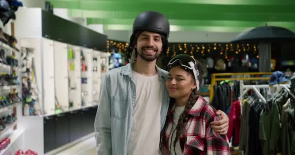 运动用品商店购物时 一对笑容满面的情侣戴着头盔和滑雪眼镜的画像 — 图库视频影像