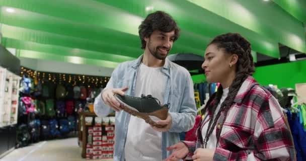 这对年轻夫妇在体育商店里挑选鞋子 — 图库视频影像