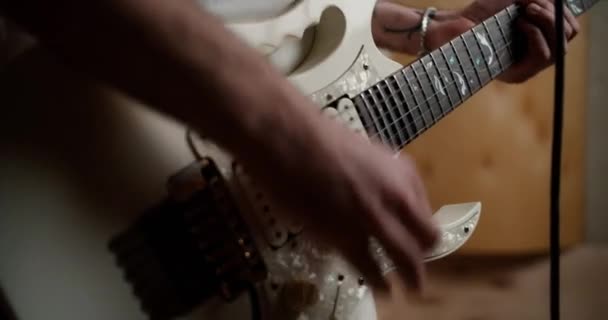男はホームスタジオでギターを演奏 低角度表示 — ストック動画