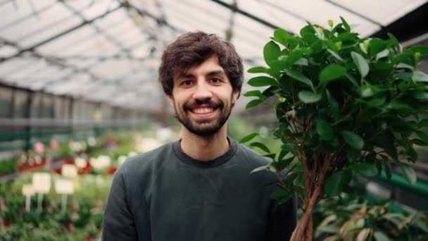 Hombre Sonriente Sosteniendo Maceta Con Árbol Decorativo Centro Jardín — Vídeo de stock