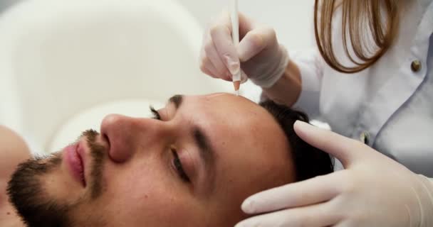 医生在男性脸上做记号 美容师或外科医生会诊的英俊大胡子男人 — 图库视频影像