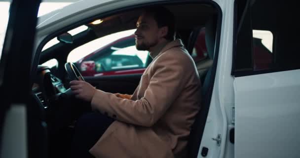 Fiatal Férfi Ügyfél Belül Autó Miközben Vásárol Modern Bemutatóteremben — Stock videók