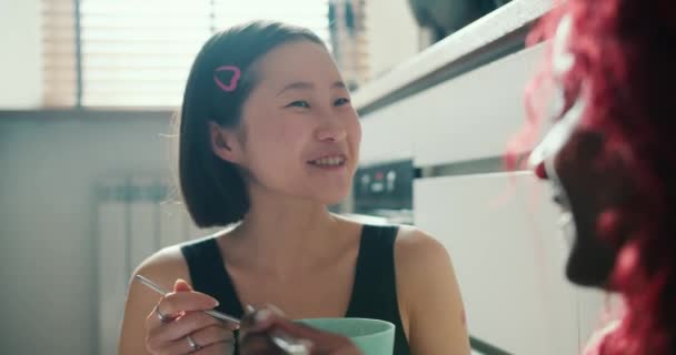 Asiática Chica Come Desayuno Tazón Con Amigo Sentado Suelo Cocina — Vídeos de Stock