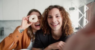 Arkadaşlar evde komik suratlar yapar, kızlar donutla göz kapatıyorlar..
