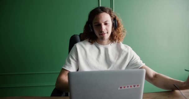 Ελεύθερος Επαγγελματίας Στα Ακουστικά Κοιτάζοντας Οθόνη Φορητού Υπολογιστή Βάζοντας Γυαλιά — Αρχείο Βίντεο
