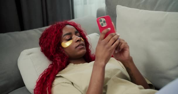 モバイルを使用して目のパッチを持つ若い美しいアフリカの女性 入力メッセージ — ストック動画
