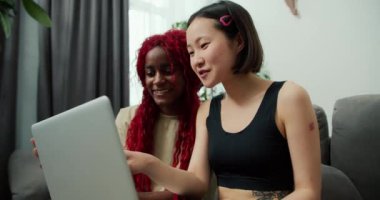 Genç kadınlar internette dizüstü bilgisayarla sörf yapıyor, arkadaşlar zor bir haftadan sonra dinleniyor..