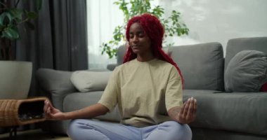 Genç, şık, Afro-Amerikan kadın lotus pozisyonunda oturuyor gözleri kapalı sağlıklı sakin kız meditasyonda dinleniyor..