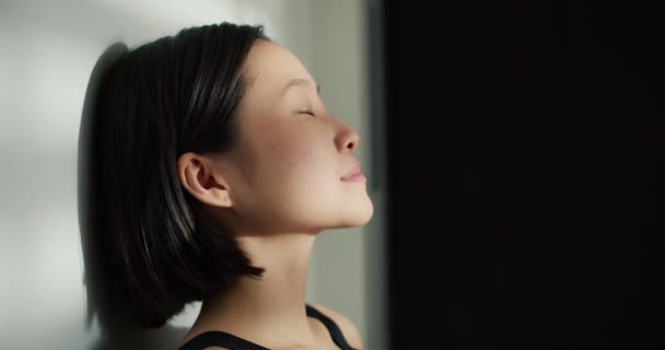 一个美丽而柔软的中国女人双目紧闭躺在地板上的侧像 — 图库视频影像