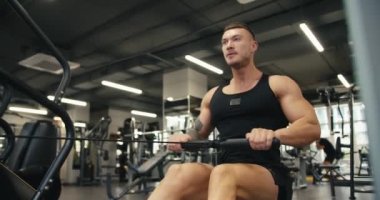 Ağır çekimde genç sporcu sırt ve göğüs kaslarını güçlendirmek için ağırlık egzersizleri yapar. Spor salonunda egzersiz olarak yatay blok çekme.