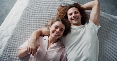 Sevimli milenyum aşıkları kameraya bakıyor, yataklarında uzanıyor, manzarası güzel..