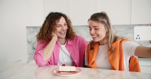 幸せな若いカップルや友人吹いて誕生日ケーキキャンドル一緒にとビデオ通話を行う — ストック動画
