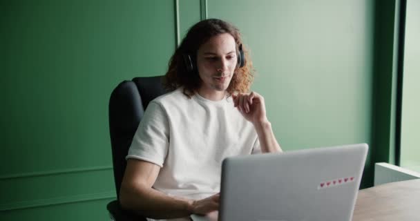 Freelancer Słuchawkach Patrząc Ekran Laptopa Pracując Zdalnie Domu — Wideo stockowe