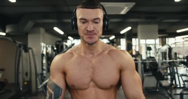 Young Man Tattoo Wearing Headphones Does Warm Walks Treadmill — Stock Video