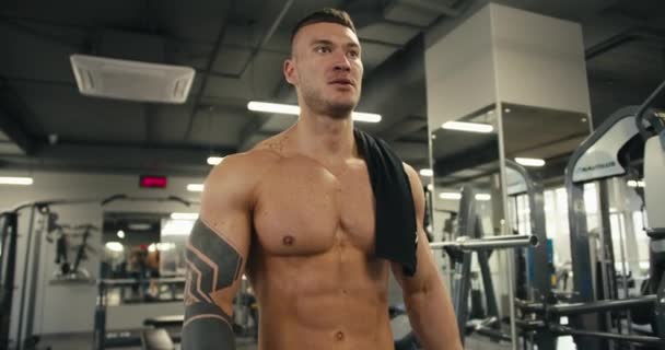 Egy Fiatal Férfi Atléta Meztelen Felsőtesttel Tetoválással Sétál Tornateremben — Stock videók