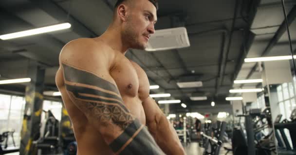 Молодой Человек Обнаженным Туловищем Татуировкой Приближается Специальному Тренажеру Выполнить Упражнение — стоковое видео
