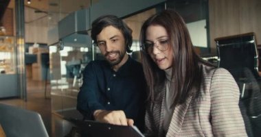 Kat İşbirliği: Laptop 'ta birlikte çalışan iki ofis çalışanı. Ofis çalışanı ve kız, adam gözlüklü kıza yeni bilgiler veriyor..