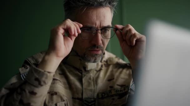 自宅でノートパソコンで作業眼鏡の兵士 予備軍の軍人の日常生活 仕事とコミュニケーションをオンラインで — ストック動画