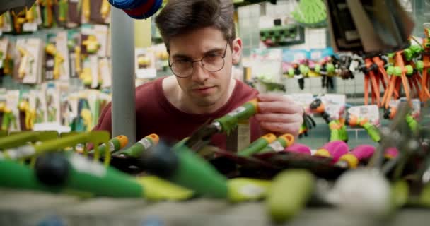 Gartengeräte Einkauf Mit Einem Jungen Mann Braunem Pullover Und Brille — Stockvideo