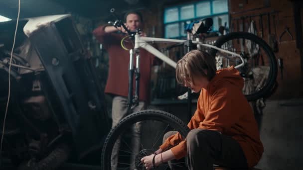 自転車修理ワークショップで父と息子のチームワーク — ストック動画