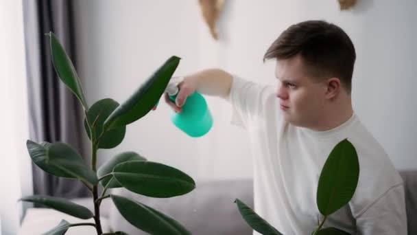 Человек Синдромом Дауна Распыляет Комнатные Растения Осторожностью — стоковое видео