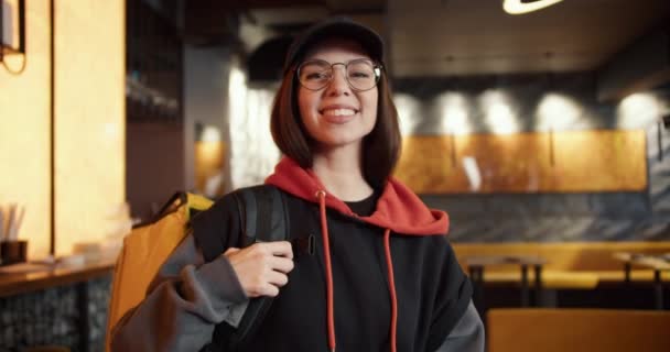 Joven Repartidor Sonriente Mujer Con Gorra Pie Con Mochila Restaurante — Vídeos de Stock