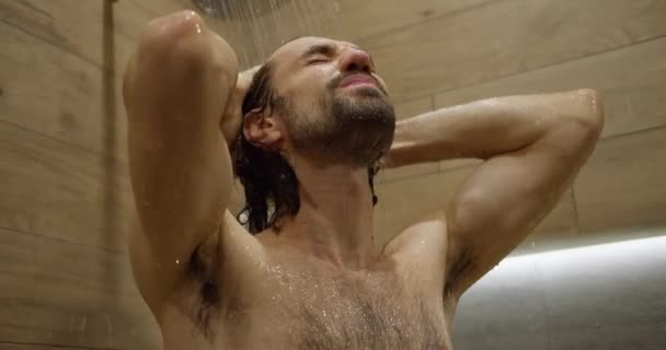 現代のシャワーで暗い髪の男性の洗髪と顔のクローズアップ 正面図 — ストック動画