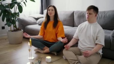 Down sendromlu bir kadının portresi. Evde meditasyon yapıyor. Ağır çekimde..