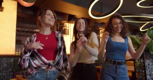 舞会的乐趣 三个快乐的女孩在阳光咖啡店的巴切洛蕾特派对上跳舞 — 图库视频影像