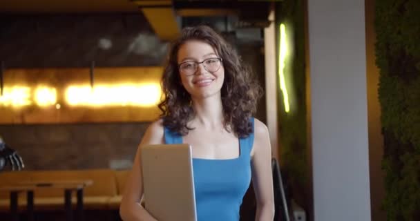 技术上明智的魅力 一个阳光灿烂的餐馆里穿着蓝色上衣 头戴餐具的年轻女性 — 图库视频影像