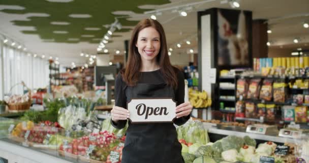 欢迎光临 穿着深色制服的女性员工 在高质量超级市场镜头中的开放标志 — 图库视频影像