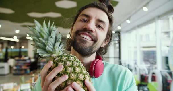 活気に満ちたパイナップルビブ 遊び心のある緑のTシャツの男のスーパーマーケットの楽しみ — ストック動画