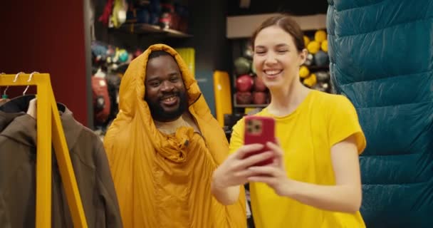 喜びの瞬間 アフリカ系アメリカ人の男とヨーロッパ人の女の子ハイキングギア店でヒラリー セルフィー アドベンチャー — ストック動画