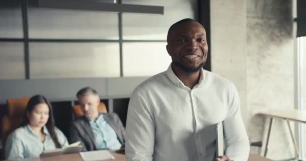 Czarna Osoba Uśmiecha Się Patrzy Kamerę Tle Biura Mężczyzna Średnim — Wideo stockowe