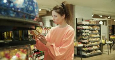 Her gün Alışveriş: Şeftalili Genç Kadın Süpermarketten Eşyalar Seçiyor.