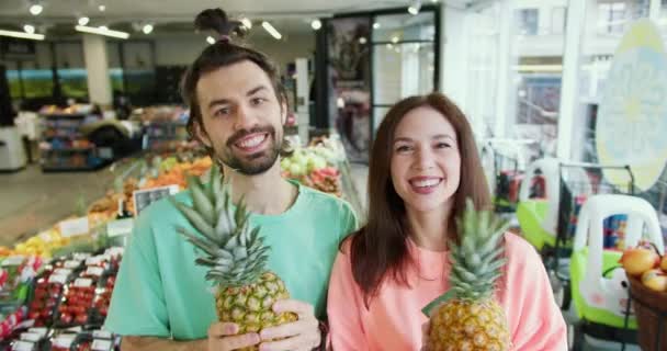 对称柑橘舞 年轻的布鲁内特夫妇与菠萝共舞 欢笑与嬉戏 — 图库视频影像