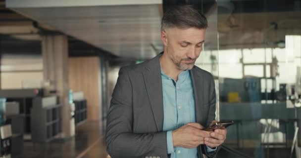 Egy Középkorú Ősz Hajú Szürke Öltönyös Férfi Dolgozik Telefonban Iroda — Stock videók