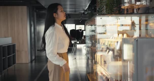 Ung Brunett Asiatisk Flicka Vit Skjorta Inspekterar Ett Skyltfönster Med — Stockvideo