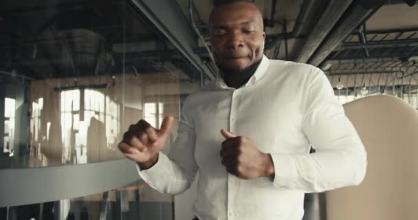 一个中年黑人在办公室里跳舞 穿白衬衫的男人休息时在办公室里听音乐和跳舞 — 图库视频影像