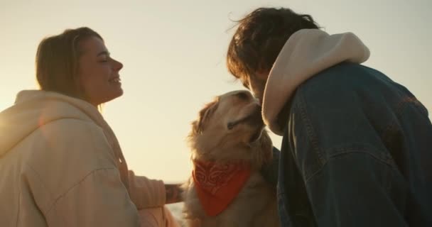 朝の晴れたビーチで犬とピクニックをしているカップルのクローズアップショット — ストック動画