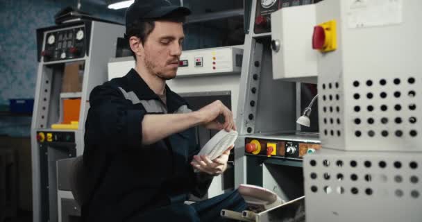Ένας Άντρας Ειδική Μπλε Στολή Κάθεται Και Δουλεύει Μηχανές Κατασκευής — Αρχείο Βίντεο