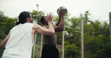Siyah derili ve çıplak gövdeli bir adam takım arkadaşından basketbol topu alır. Herkes harika bir gol attığı için mutlu..