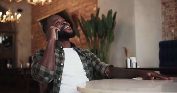 黑人在咖啡店打电话时大笑 休息一下 — 图库视频影像